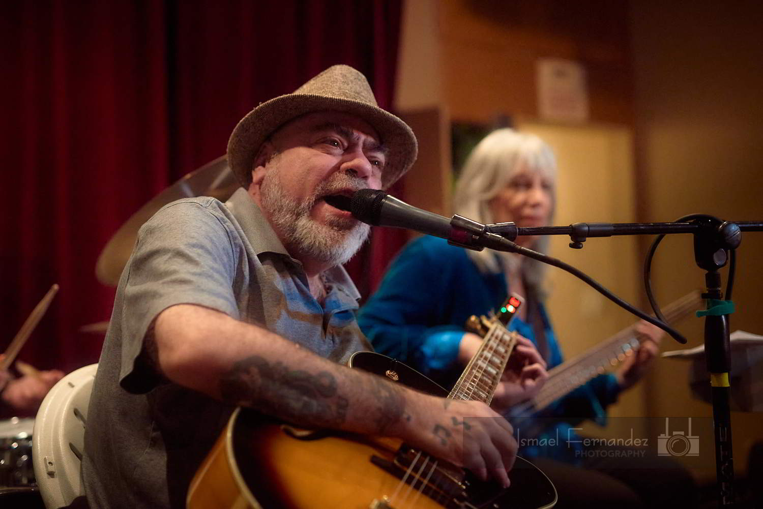 Big Frank sings into the microphone. The healers are behind him. 