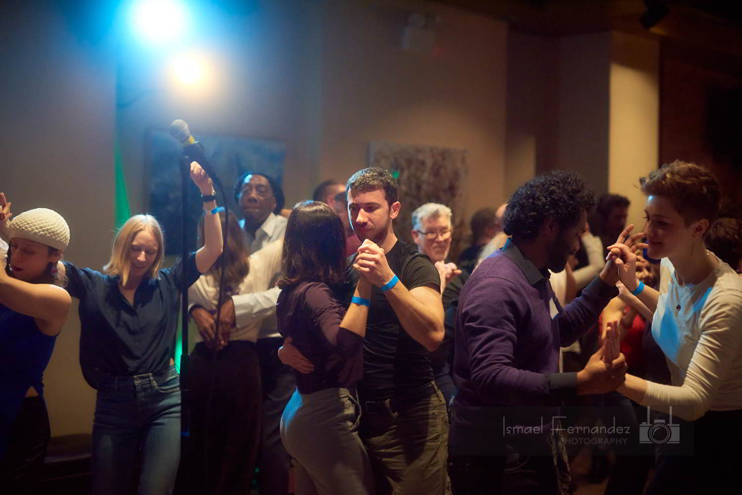Dancers dance the blues solo and in pairs on the dance floor. 